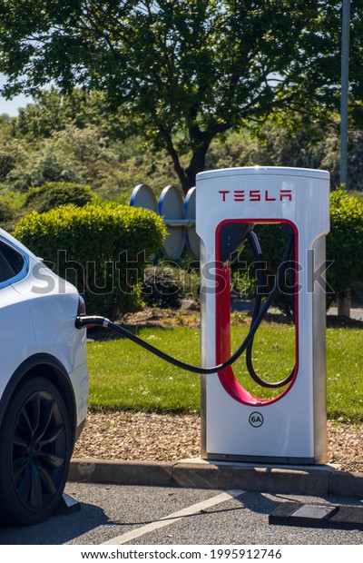 Grantham, UK - May 30th 2021:\
Tesla Model X plugged into a supercharger. In a motorway service\
area.