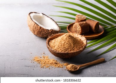 Granular and block shape of organic brown palm sugar or coconut sugar made from coconut juice on grey concrete background with copyspace.
