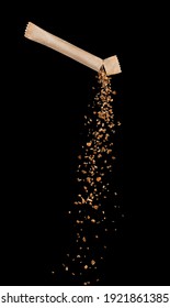 Granules Of Freeze Dried Instant Coffee Pouring From The Stick Packaging On Black Background