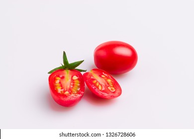 Grape or cherry tomato branch. Pile of red grape tomatoes cut, isolated on white background, soft light, angle view, studio shot.