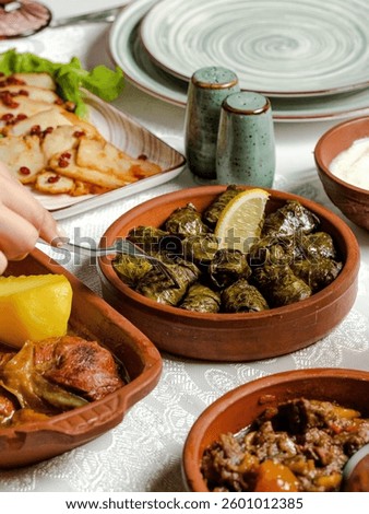 Grape dolma in ceramic pot, dolma on fork