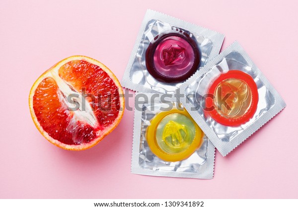 Grapefruit Condoms On Pink Background Stock Photo E