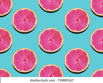Grapefruit in flat lay Fruity pattern of grapefruit with pink flesh on a turquoise background Top view Modern flat lay photo pattern in pop art style