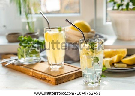 Grapefruit gin and tonic selection drink alcohol cocktail or detox water on the white table near window in the sunny falltime, refreshing drink with ice, elective focus, shallow depth of the field.