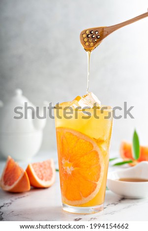 Grapefruit honey jasmine tea served cold with ice in a tall glass