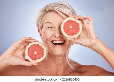 Grapefruit, portrait of happy senior woman in studio or natural skincare product for vegetarian lifestyle. Detox diet for retirement, elderly healthcare nutritionist on gray background or clean face