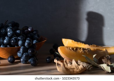 Grapes and figs on the table. Shadow bottle of wine in the background. - Shutterstock ID 1023343573