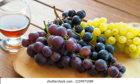 grapes and glasses on a wooden tray