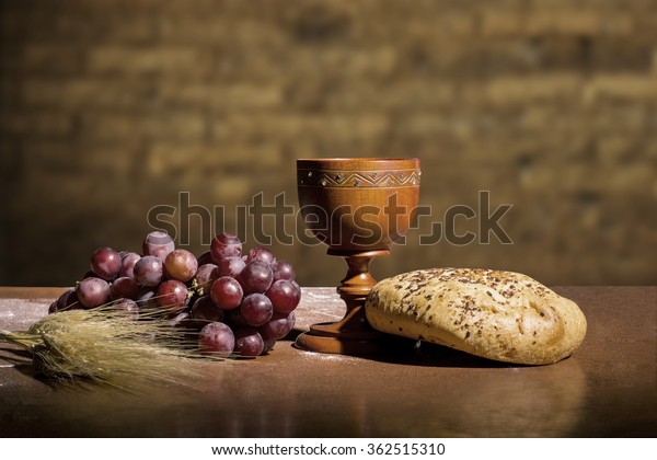 grapes, wheat, bread and wine on a wood table