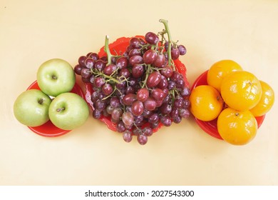 Grapes,Oranges and Apples in red plate,put on background,auspicious fruit - Shutterstock ID 2027543300