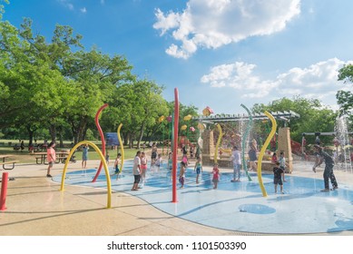 GRAPEVINE, TX, US-May 28, 2018:Diverse Kids Enjoy Water Splash Pad Or Sprayground At Parr Park. Water Fountain Activities For Child And Parent During Summer Time. Outdoor Healthily Children Activity