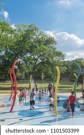 GRAPEVINE, TX, US-May 28, 2018:Diverse Kids Enjoy Water Splash Pad Or Sprayground At Parr Park. Water Fountain Activities For Child And Parent During Summer Time. Outdoor Healthily Children Activity