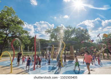 GRAPEVINE, TX, US-May 28, 2018:Diverse Kids Enjoy Water Splash Pad Or Sprayground At Parr Park. Water Fountain Activities For Child And Parent During Summer Time. Outdoor Healthily Children Activity