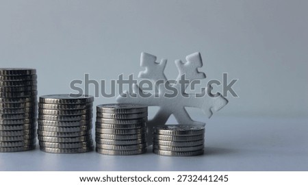 A graph of declining profits depicted as stacks of coins and a snowflake at the end of the row, symbolizing the freezing of business projects. The row of coins of varying heights ends with a symbol of cold, denoting a financial crisis