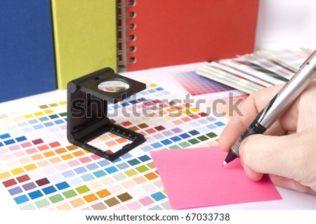 graphic design and coloured swatches and pens on a desk
