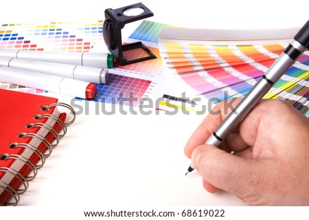 graphic design and coloured swatches and pens on a desk