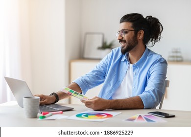 Graphic Design Courses Online. Young Arab Man Holding Colour Swatch And Using Laptop Computer At Home, Study In Internet, Eastern Male Freelance Designer Planning Gamma For Future Interior, Free Space - Powered by Shutterstock