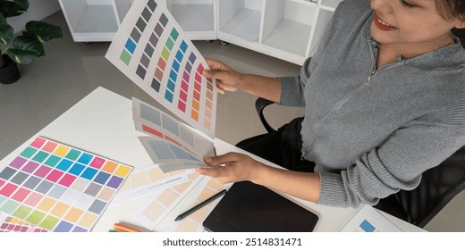 Graphic designer analyzing color samples at desk - Powered by Shutterstock