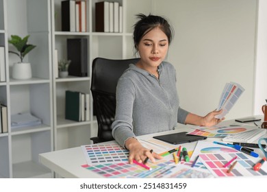 Graphic designer analyzing color swatches at desk - Powered by Shutterstock