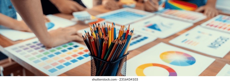 Graphic designer brainstorm logo and graphic art at busy creative studio workshop. Experiment and brainstorm color palette and pattern at workspace table for creative design. Panorama shot. Scrutinize - Powered by Shutterstock