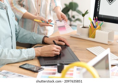 Graphic Designer With Colleague Working In Office