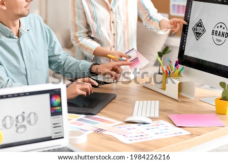 Graphic designer with colleague working in office