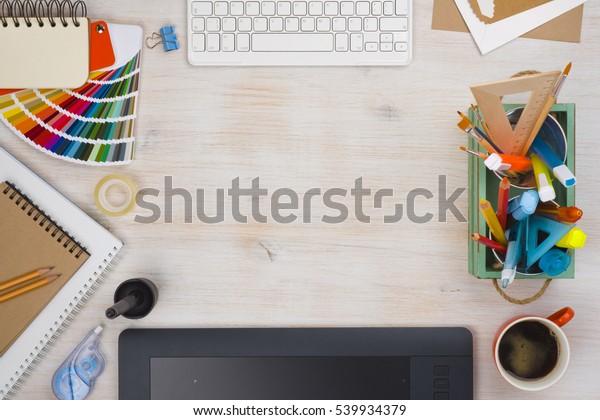 Graphic designer desk essentials top view\
with wooden texture\
background.