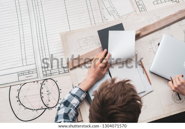 graphic designer doing calculations on the new\
building schemes