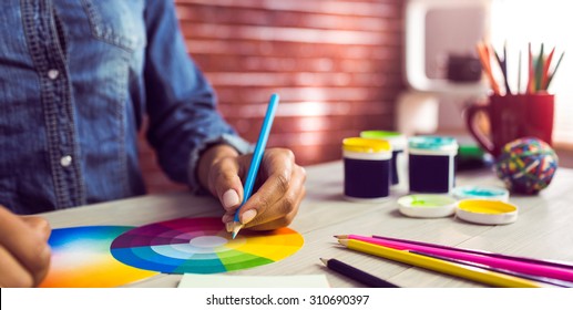 Graphic Designer Drawing On Colour Chart At Workplace