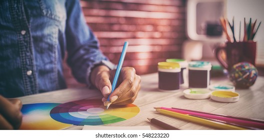 Graphic designer drawing on colour chart at workplace