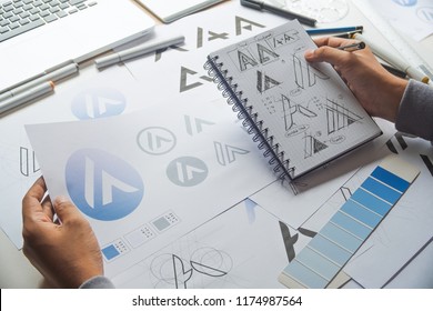 Graphic designer drawing sketch design creative Ideas draft Logo product trademark label brand artwork. Graphic designer studio Concept. - Shutterstock ID 1174987564
