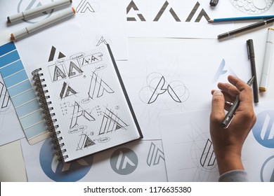 Graphic designer drawing sketch design creative Ideas draft Logo product trademark label brand artwork. Graphic designer studio Concept. - Shutterstock ID 1176635380