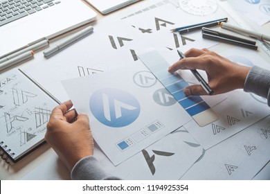 Graphic designer drawing sketch design creative Ideas draft Logo product trademark label brand artwork. Graphic designer studio Concept. - Powered by Shutterstock