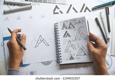 Graphic designer drawing sketch design creative Ideas draft Logo product trademark label brand artwork. Graphic designer studio Concept. - Shutterstock ID 1194925357