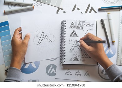 Graphic designer drawing sketch design creative Ideas draft Logo product trademark label brand artwork. Graphic designer studio Concept. - Shutterstock ID 1210841938