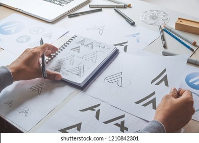 Graphic designer drawing sketch design creative Ideas draft Logo product trademark label brand artwork. Graphic designer studio Concept. - Shutterstock ID 1210842301