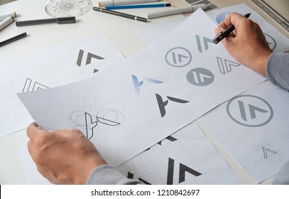 Graphic designer drawing sketch design creative Ideas draft Logo product trademark label brand artwork. Graphic designer studio Concept. - Shutterstock ID 1210842697