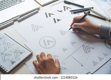 Graphic designer drawing sketch design creative Ideas draft Logo product trademark label brand artwork. Graphic designer studio Concept. - Shutterstock ID 1214083126