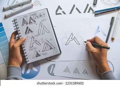 Graphic designer drawing sketch design creative Ideas draft Logo product trademark label brand artwork. Graphic designer studio Concept. - Shutterstock ID 1231589602