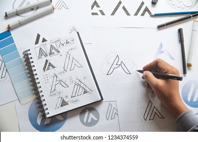 Graphic designer drawing sketch design creative Ideas draft Logo product trademark label brand artwork. Graphic designer studio Concept. - Shutterstock ID 1234374559