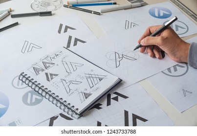 Graphic designer drawing sketch design creative Ideas draft Logo product trademark label brand artwork. Graphic designer studio Concept. - Shutterstock ID 1243733788