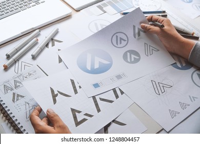 Graphic designer drawing sketch design creative Ideas draft Logo product trademark label brand artwork. Graphic designer studio Concept. - Shutterstock ID 1248804457