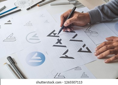 Graphic designer drawing sketch design creative Ideas draft Logo product trademark label brand artwork. Graphic designer studio Concept. - Shutterstock ID 1265507113