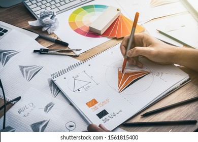 Graphic designer drawing sketches logo design. The concept of a new brand. Professional creative occupation with idea. - Shutterstock ID 1561815400