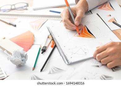Graphic designer drawing sketches logo design. The concept of a new brand. Professional creative occupation with idea. - Shutterstock ID 1694148316