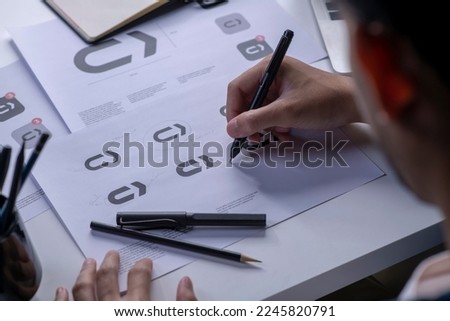 Graphic designer drawing sketches logo design. The concept of a new brand. Professional creative occupation with idea.