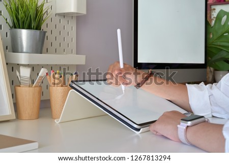 Graphic designer hand using digital drawing sketch tablet pen in studio