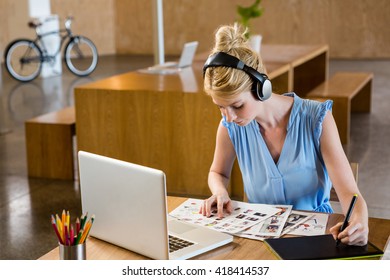 Graphic designer looking at chart while using graphic tablet in office - Powered by Shutterstock