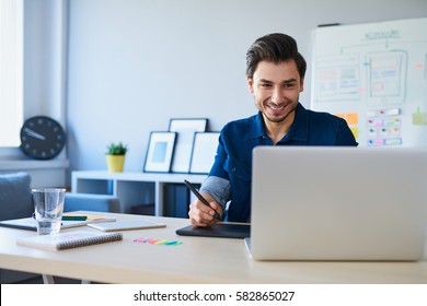 Graphic designer sketching new project on tablet working with laptop in office - Powered by Shutterstock