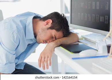 Graphic designer sleeping on the keyboard in his office - Powered by Shutterstock